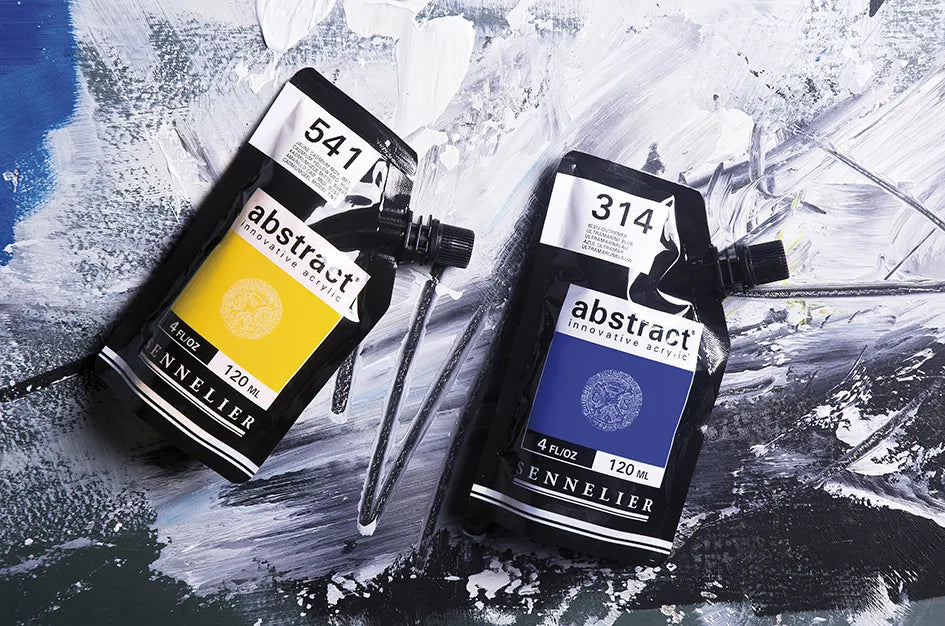 Painted abstract blue and black background with thick white acrylic overpainted and two packets of acrylic sitting on top